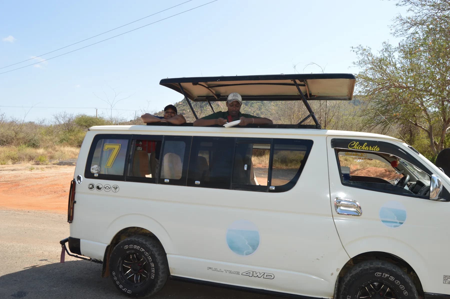 A white safari van with its pop-up roof raised
