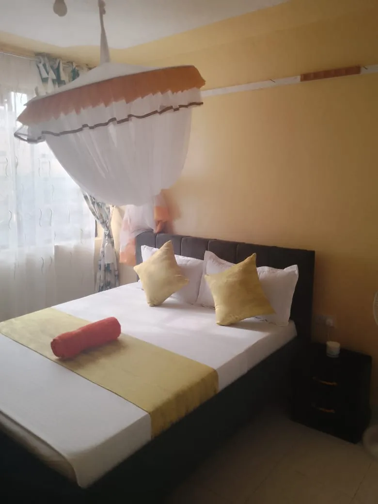 A bright bedroom with yellow cushions in a Nyali apartment